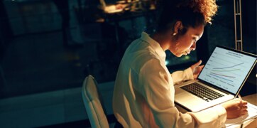 Kobieta siedząca przed ekranem laptopa